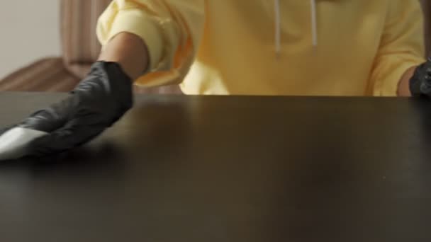 Close-up of a womans hands in black nitrile gloves, cleaning a table, using a rag — Stock Video