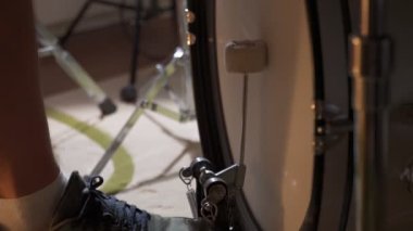 Çift pedallı bir rock grubunda davulcunun bacağı. Davulcu ayağı spor ayakkabı giyer Bas davul pedalı çalar