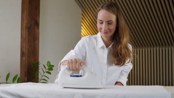 Młoda ładna uśmiechnięta kobieta żelazka czysta bielizna w domu — Wideo stockowe
