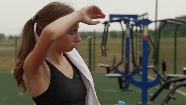 Deportiva mujer beber agua después de hacer ejercicio al aire libre — Vídeos de Stock