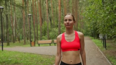 Genç bir kadın renkli bir sonbahar ormanında koşuyor - dışarıda koşuyor. 