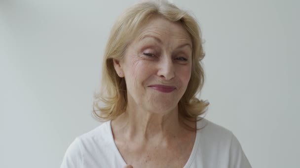 El concepto de tener fuertes dientes blancos sanos perfectos en la vejez. Retrato de una anciana con una sonrisa radiante, señalando sus dientes, mostrando un pulgar hacia arriba — Vídeos de Stock