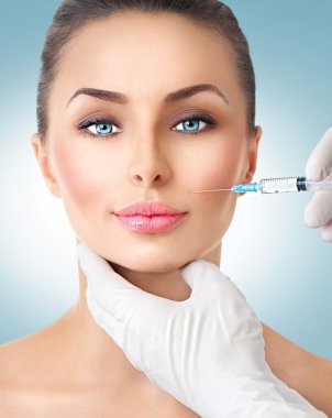 Beauty woman gets facial injections. clipart