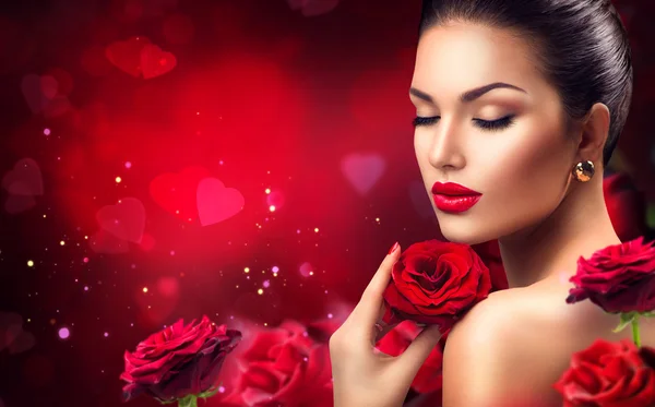 Žena s červenými květy růže. — Stock fotografie