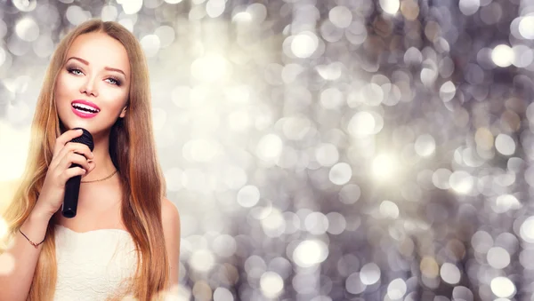 Fille avec un microphone chantant — Photo