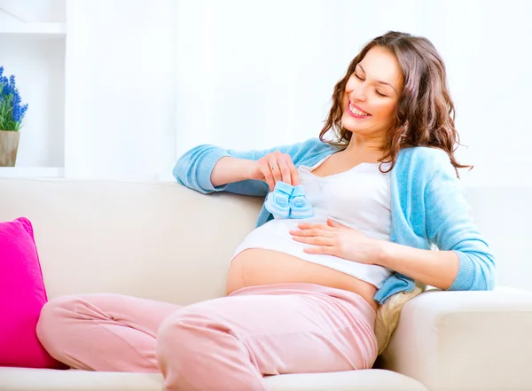 Woman holding baby shoes — Stock Photo, Image