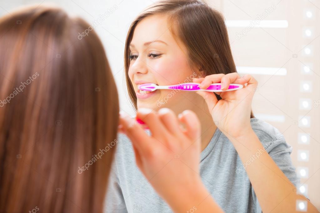 Teenage girl brushing her teeth