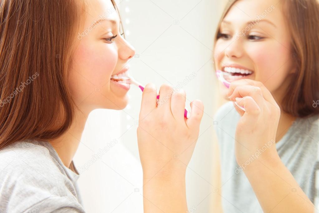 Teenage girl brushing her teeth