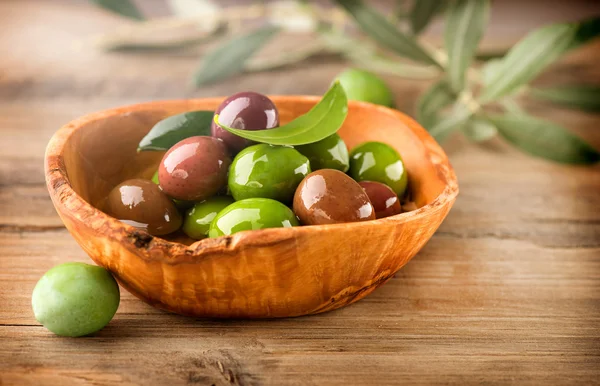 Оливки и оливковое масло на столе — стоковое фото