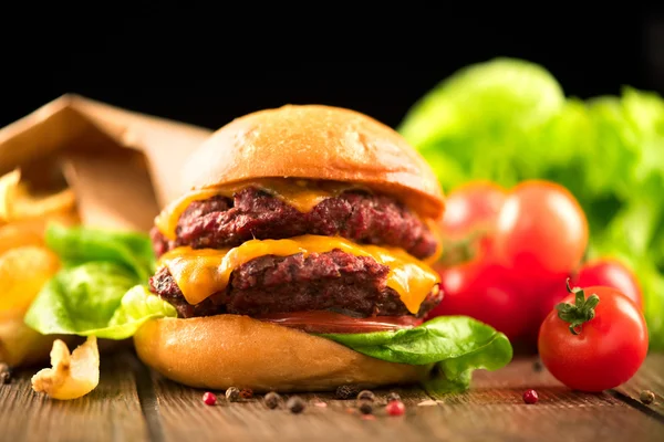 Cheeseburger con patatine fritte sul tavolo — Foto Stock