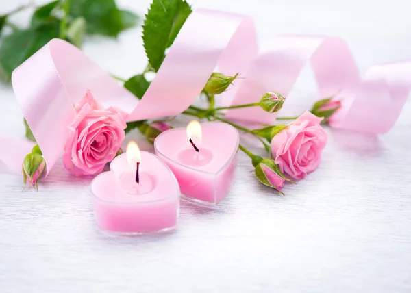 Pink heart shaped candles and rose