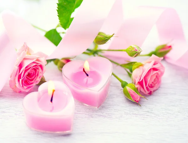 Kaarsen en roze bloemen — Stockfoto