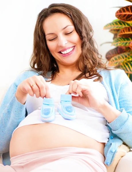 Pregnant woman holding  baby shoes — Stock Photo, Image