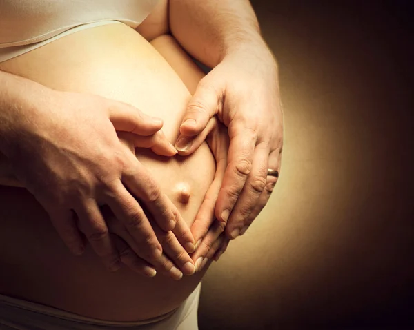Pregnant woman and  husband  caressing  belly — Stock Photo, Image