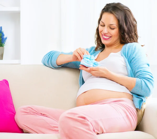 Pregnant woman holding  baby shoes — Stock Photo, Image