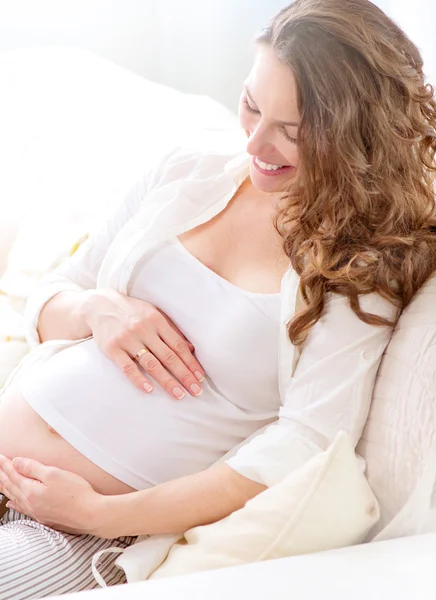 Έγκυος που κάθεται στον καναπέ — Φωτογραφία Αρχείου