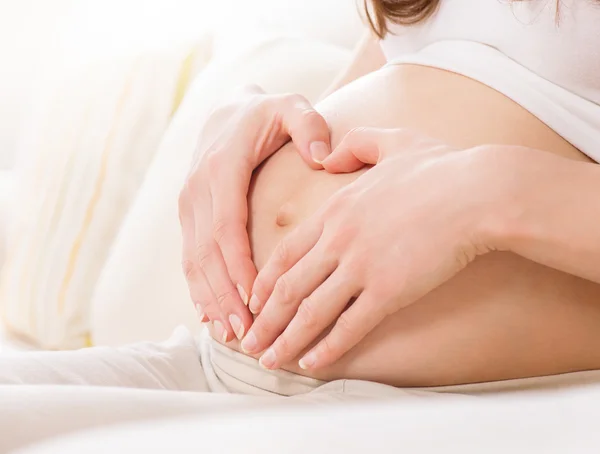 Zwanger vrouw houden haar buik — Stockfoto