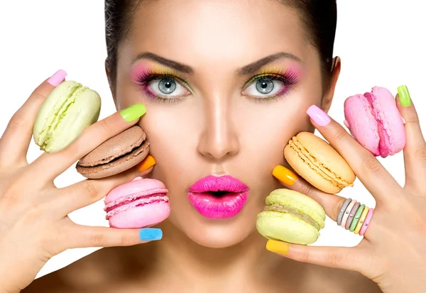 Modelo menina tomando macaroons coloridos — Fotografia de Stock