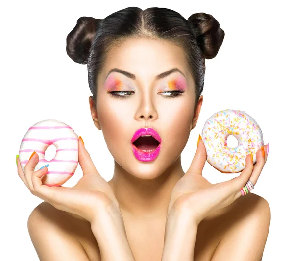 Menina tomando donuts coloridos . — Fotografia de Stock