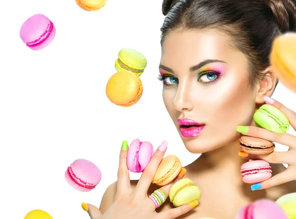 Modelo menina tomando macaroons coloridos — Fotografia de Stock