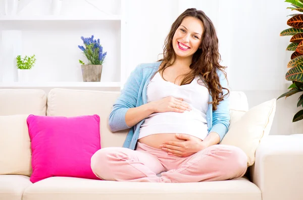 Gravid kvinna smeker magen Royaltyfria Stockfoton