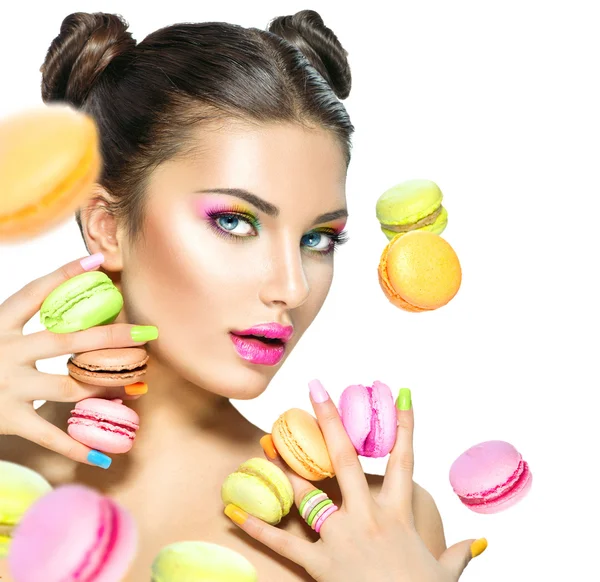 Modelo chica tomando coloridos macarrones —  Fotos de Stock