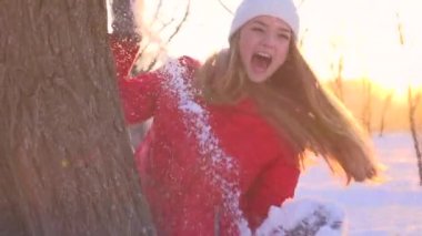 Young woman throwing  snowball