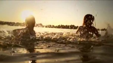 Gençler yaz günbatımı üzerinde püskürtme