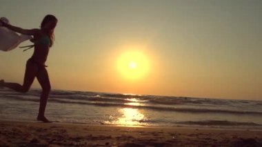 Kız bikinili kumsalda dans