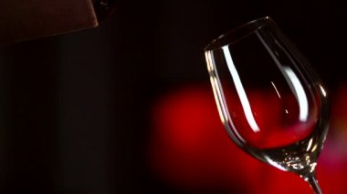 kırmızı şarap bardağa dökülüyor.
