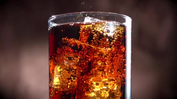 Cola s ledem a bublinkami ve skle. — Stock video