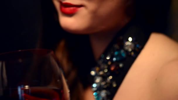 Mujer joven bebiendo vino tinto — Vídeo de stock