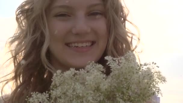 Девочка пахнет дикими цветами — стоковое видео