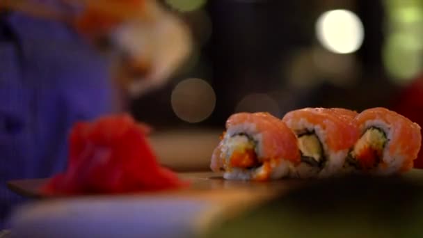 Junge Frau isst Sushi-Brötchen. — Stockvideo