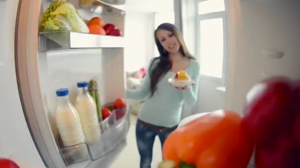 Chica abre refrigerador puerta — Vídeo de stock