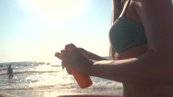 Молодая женщина наносит солнцезащитный крем — стоковое видео
