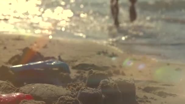 Маленькая девочка строит замок из песка — стоковое видео