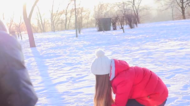 Pareja joven lanzando bolas de nieve — Vídeo de stock