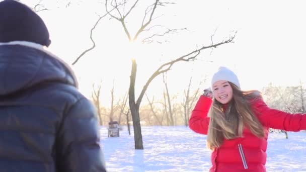 Pareja joven lanzando bolas de nieve — Vídeos de Stock