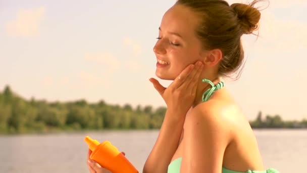 Adolescente chica aplicando protector solar — Vídeo de stock