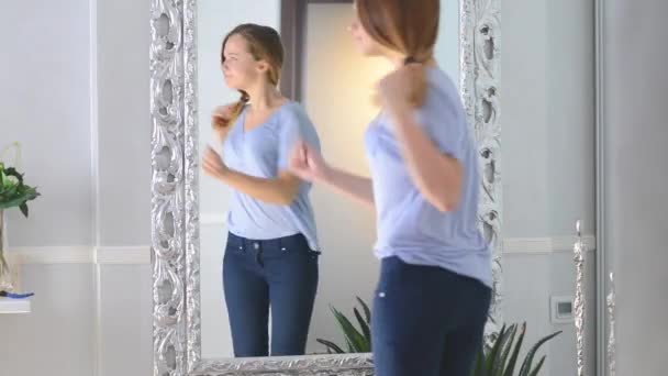 Girl looks at herself in mirror — Stock Video