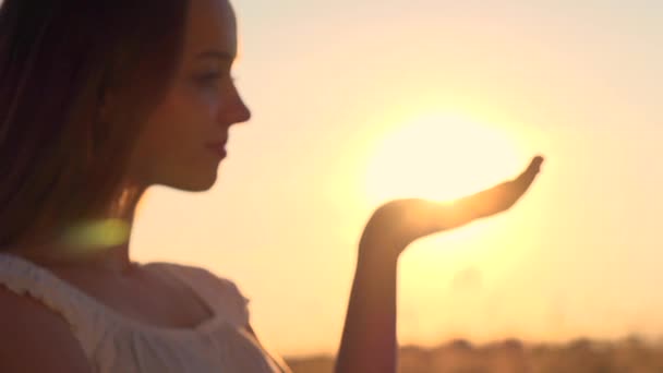 Mulher mão pegando sol contra o pôr do sol — Vídeo de Stock
