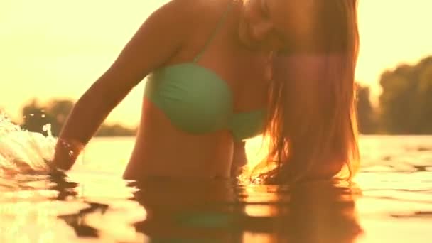 Model meisje opspattend water in de rivier. — Stockvideo