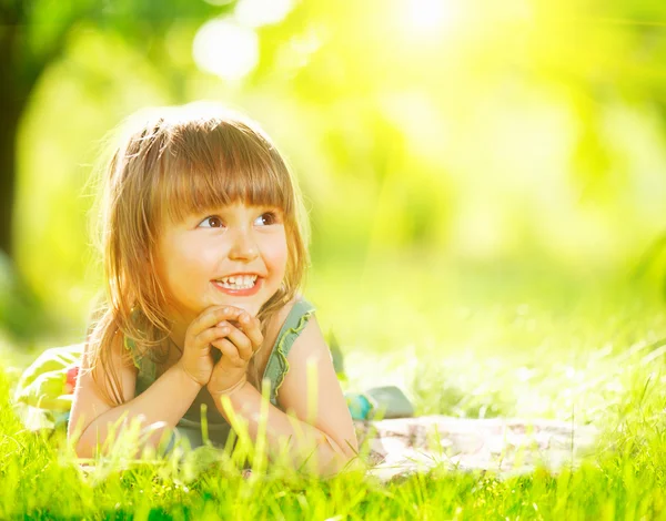 Petite fille couchée sur l'herbe verte — Photo