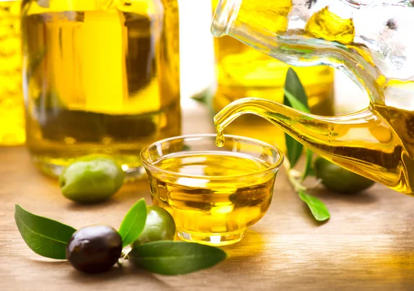 Bouteille versant l'huile d'olive vierge — Photo