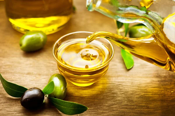 Olio vergine di oliva versato in ciotola — Foto Stock