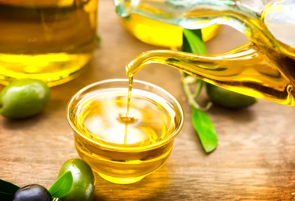 Aceite de oliva virgen vertiendo en un tazón —  Fotos de Stock