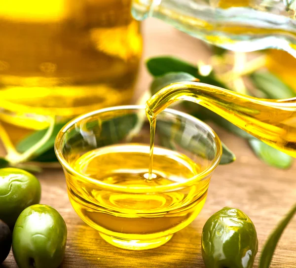 Natives Olivenöl in Schüssel gießen — Stockfoto