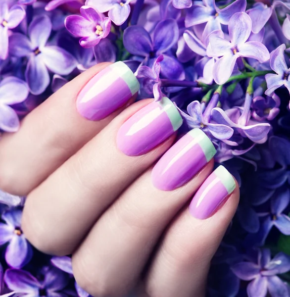 Violet met groene manicure met lila bloemen — Stockfoto