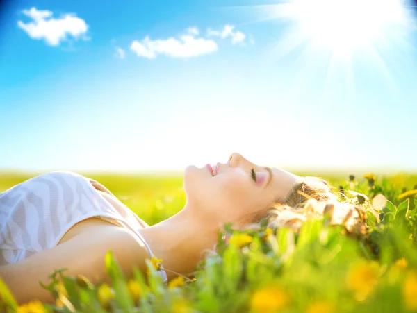 Chica acostada en el campo de verano con flores — Foto de Stock